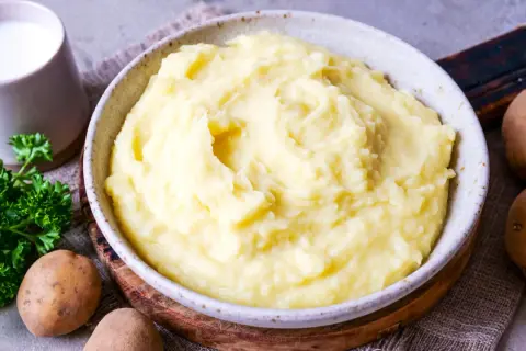 Cremiger Kartoffelbrei, perfekt für jedes Kartoffelbrei Rezept. Dazu frische Petersilie und Milch.