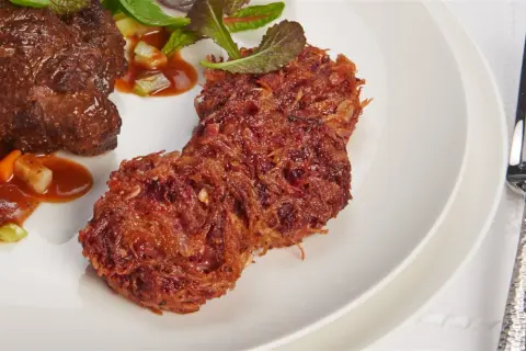 Herzhaftes Rinderfilet mit einer Beilage aus knusprigen rote Bete puffer und frischem Salat.