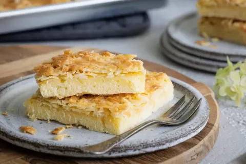 Zwei Stücke saftiger Butterstreuselkuchen mit knuspriger Mandelkruste auf einem Teller. Ein köstliches Rezept für Butterstreuselkuchen.