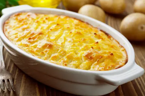 Herzhaftes Kartoffelgratin mit gekochten Kartoffeln, goldbraun überbacken, bereit zum Servieren.