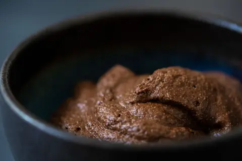 Luftige Mousse au Chocolat in einer dunklen Schale, bereit zum Genießen.