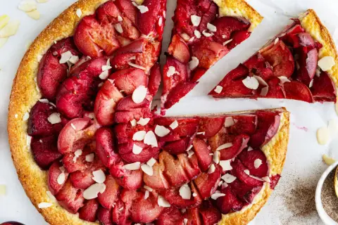 Ein schneller Pflaumenkuchen mit Quark, belegt mit saftigen Pflaumen und Mandelsplittern. Perfekt für den Kaffeetisch!
