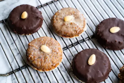 Leckeres Rezept für Elisenlebkuchen: Dunkel und hell glasierte Lebkuchen mit Mandeln auf einem Gitter.