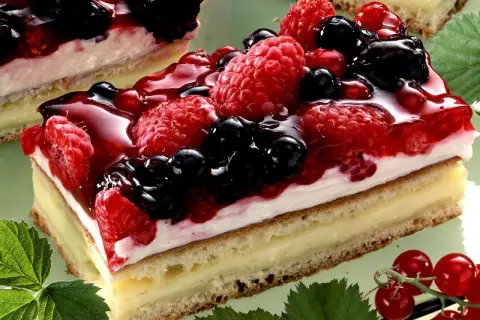 Ein saftiger **Beerenkuchen vom Blech** mit Himbeeren, Brombeeren und Blaubeeren, überzogen mit glänzendem Gelee.