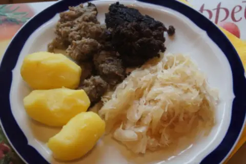 Herzhaftes Gericht: Bratwurst, Blutwurst, Sauerkraut und Salzkartoffeln. Perfekt, um Wellwurst zuzubereiten und zu genießen.