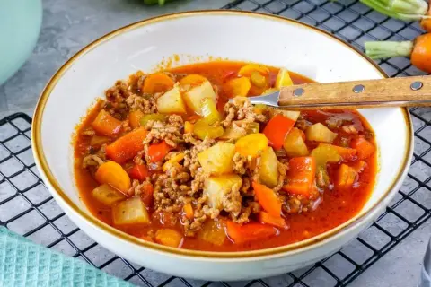 Herzhafte Hackfleisch-Gemüse-Suppe, perfekt für rezepte ohne kohlenhydrate. Mit Kartoffeln, Karotten und Paprika in würziger Tomatenbrühe.