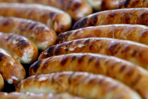 Reife Bratwürste auf dem Grill, die Frage "woher kommt die Bratwurst" wird hier kulinarisch beantwortet.