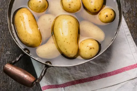 Kleine, gelbe Kartoffeln in einem Topf mit Wasser, bereit zum Kochen. So einfach ist es, Kartoffeln zuzubereiten!