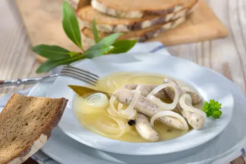 Saure Zipfel mit Zwiebeln und Brot. Ein herzhaftes Gericht, das zum Genießen einlädt.