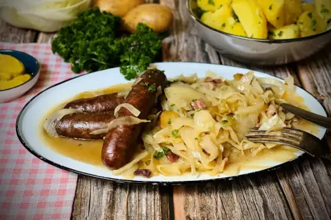 Herzhaftes bayrisch Kraut mit drei Würsten, Zwiebeln und Speck. Dazu Salzkartoffeln und Petersilie.