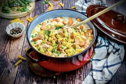 Herzhaftes Nudelgericht mit Würstchen, Erbsen und Hähnchen in cremiger Soße. Perfekt für die Frage: was koche ich heute?