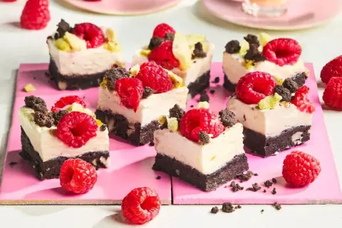 Kleine, cremige Kuchenstücke mit Himbeeren und Schokostückchen, perfekt für den Sommer.