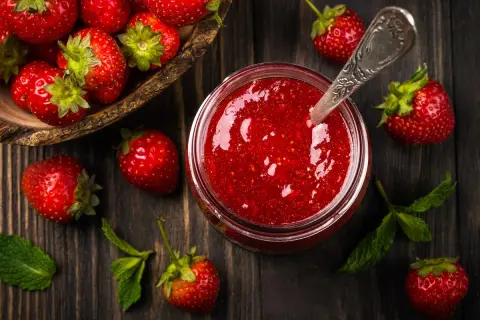 Frische Erdbeeren und ein Glas selbstgemachte Erdbeermarmelade. Ein einfaches Erdbeermarmelade Rezept für den Sommer.