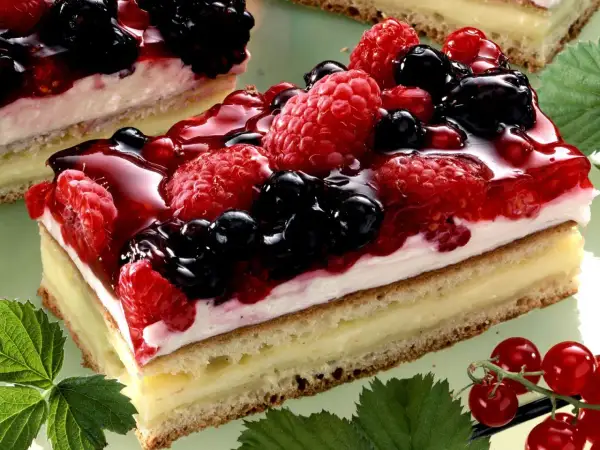 Ein saftiger **Beerenkuchen vom Blech** mit Himbeeren, Brombeeren und Blaubeeren, überzogen mit glänzendem Gelee.