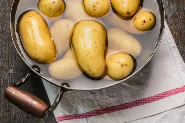 Kleine, gelbe Kartoffeln in einem Topf mit Wasser, bereit zum Kochen. So einfach ist es, Kartoffeln zuzubereiten!
